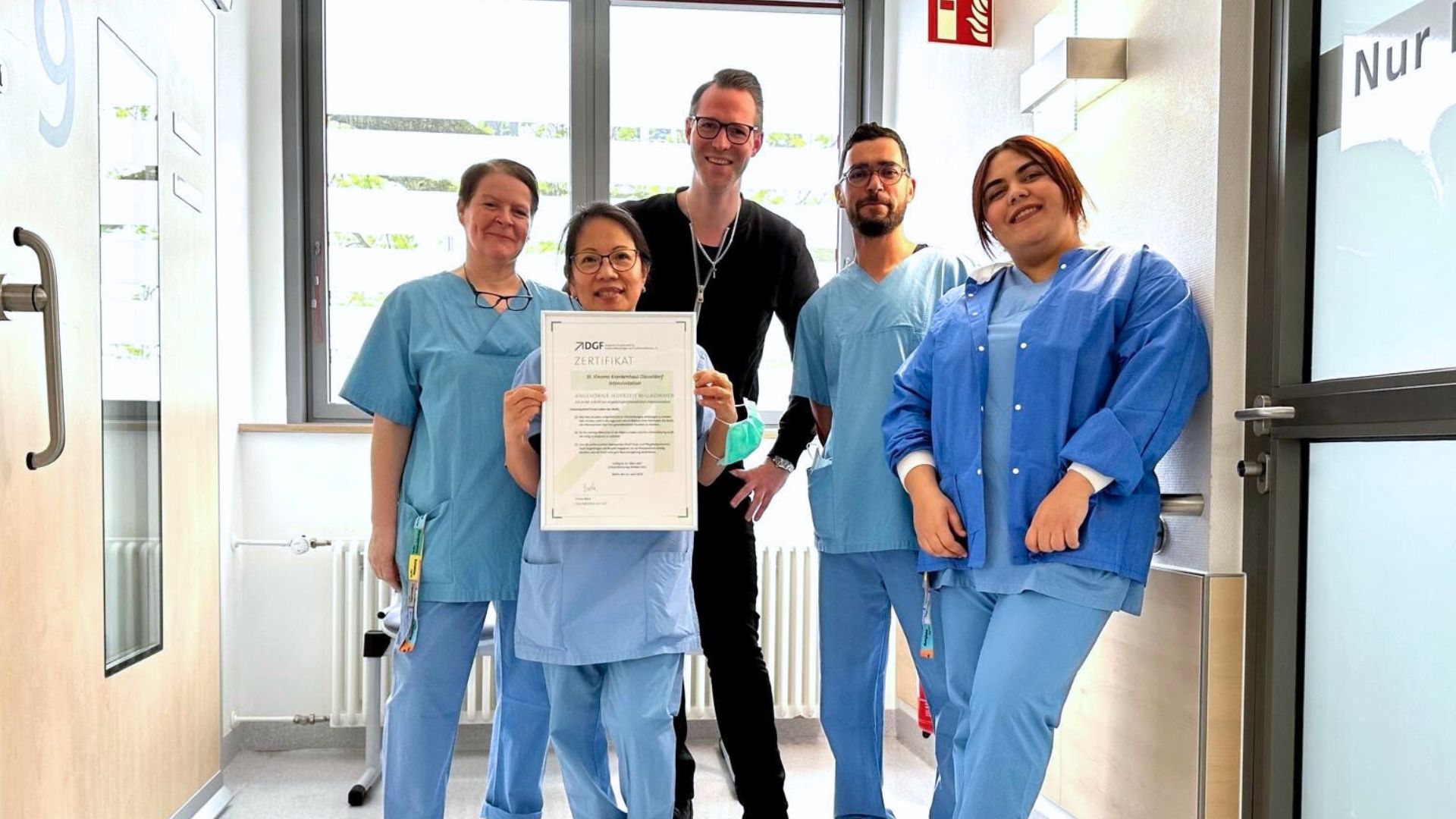 Das pflegerische Team der Intensivstation am St. Vinzenz-Krankenhaus steht auf dem Stationsflur und präsentiert das Zertifikat.